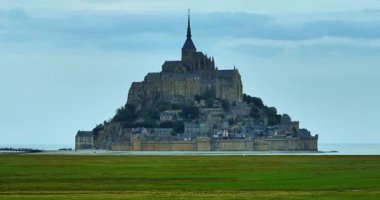 Mont Saint Michel 'in hava manzarası. Büyük bir koyun sürüsü Mont Saint Michel.Iconic Adası ve Fransa 'nın Normandiya Manastırı' nın arka planında otluyor..