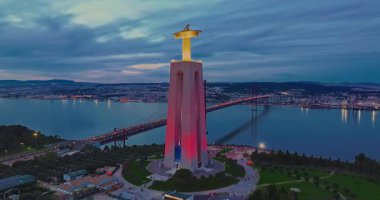 Lizbon 'daki Kral İsa' nın günbatımında Lizbon, Portekiz 'de katolik anıtı üzerindeki hava görüşü. Gece ya da akşam Sığınak 'ın kırmızı arka planı ve güzel bir akşam manzarası.