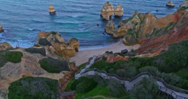 Lagos, Algarve, Portekiz 'deki Camilo plajının hava manzarası. Güzel bir sahile çıkan uzun tahta merdiven..