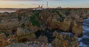 Günbatımında Ponta da Piedade, Lagos, Portekiz 'deki dramatik uçurumların ve deniz fenerinin havadan görünüşü.