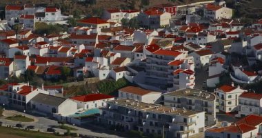 Yel değirmeni ve pitoresk çatıları olan küçük köyün havadan görünüşü, Aldatmaca, Portekiz.