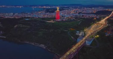 Lizbon 'daki Kral İsa' nın günbatımında Lizbon, Portekiz 'de katolik anıtı üzerindeki hava görüşü. Gece ya da akşam Sığınak 'ın kırmızı arka planı ve güzel bir akşam manzarası.