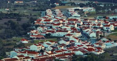 Yel değirmeni ve pitoresk çatıları olan küçük köyün havadan görünüşü, Aldatmaca, Portekiz.
