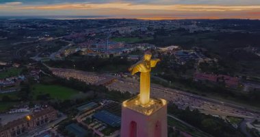 Lizbon 'daki Kral İsa' nın günbatımında Lizbon, Portekiz 'de katolik anıtı üzerindeki hava görüşü. Gece ya da akşam Sığınak 'ın kırmızı arka planı ve güzel bir akşam manzarası.