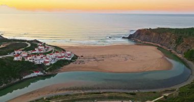 Yel değirmeni ve pitoresk çatıları olan küçük köyün havadan görünüşü, Aldatmaca, Portekiz.