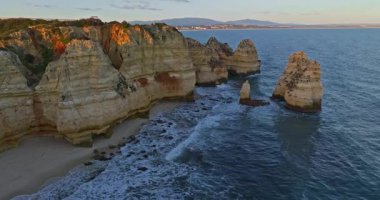 Günbatımında Ponta da Piedade, Lagos, Portekiz 'deki dramatik uçurumların ve deniz fenerinin havadan görünüşü.