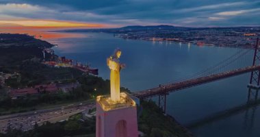 Lizbon 'daki Kral İsa' nın günbatımında Lizbon, Portekiz 'de katolik anıtı üzerindeki hava görüşü. Gece ya da akşam Sığınak 'ın kırmızı arka planı ve güzel bir akşam manzarası.