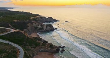 Günbatımında Portekiz 'deki uzun kayalık kıyı şeridi üzerinde hava manzarası. Okyanus kayalık kıyıları ile güzel doğal manzara.