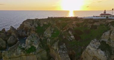 Günbatımında Ponta da Piedade, Lagos, Portekiz 'deki dramatik uçurumların ve deniz fenerinin havadan görünüşü.