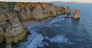 Günbatımında Ponta da Piedade, Lagos, Portekiz 'deki dramatik uçurumların ve deniz fenerinin havadan görünüşü.