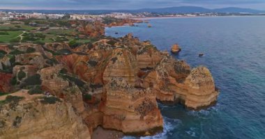 Günbatımında Ponta da Piedade, Lagos, Portekiz 'deki dramatik uçurumların ve deniz fenerinin havadan görünüşü.