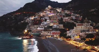 Positano 'nun havadan görünüşü. Gece vakti ışık saçan ünlü renkli evler. İtalya, Amalfi Sahili 'nde muhteşem bir mimari..