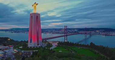 Lizbon 'daki Kral İsa' nın günbatımında Lizbon, Portekiz 'de katolik anıtı üzerindeki hava görüşü. Gece ya da akşam Sığınak 'ın kırmızı arka planı ve güzel bir akşam manzarası.