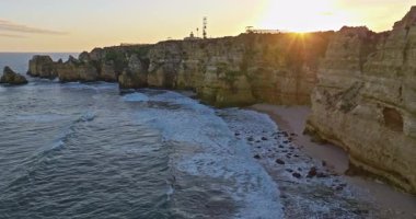 Günbatımında Ponta da Piedade, Lagos, Portekiz 'deki dramatik uçurumların ve deniz fenerinin havadan görünüşü.