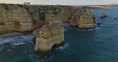 Günbatımında Ponta da Piedade, Lagos, Portekiz 'deki dramatik uçurumların ve deniz fenerinin havadan görünüşü.