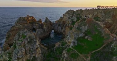 Günbatımında Ponta da Piedade, Lagos, Portekiz 'deki dramatik uçurumların ve deniz fenerinin havadan görünüşü.