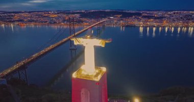 Lizbon 'daki Kral İsa' nın günbatımında Lizbon, Portekiz 'de katolik anıtı üzerindeki hava görüşü. Gece ya da akşam Sığınak 'ın kırmızı arka planı ve güzel bir akşam manzarası.