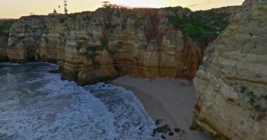 Günbatımında Ponta da Piedade, Lagos, Portekiz 'deki dramatik uçurumların ve deniz fenerinin havadan görünüşü.