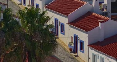 Yel değirmeni ve pitoresk çatıları olan küçük köyün havadan görünüşü, Aldatmaca, Portekiz.