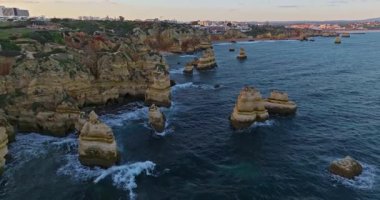 Günbatımında Ponta da Piedade, Lagos, Portekiz 'deki dramatik uçurumların ve deniz fenerinin havadan görünüşü.