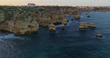 Günbatımında Ponta da Piedade, Lagos, Portekiz 'deki dramatik uçurumların ve deniz fenerinin havadan görünüşü.