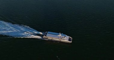 Modern beyaz süper yatın hava manzaralı takibi. Yaşam tarzı lüks yelkenli, hava aracı kuruyor. Motor yatı hareket halinde, ailesi ve arkadaşları yatta..