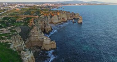 Günbatımında Ponta da Piedade, Lagos, Portekiz 'deki dramatik uçurumların ve deniz fenerinin havadan görünüşü.