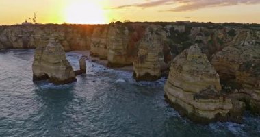 Günbatımında Ponta da Piedade, Lagos, Portekiz 'deki dramatik uçurumların ve deniz fenerinin havadan görünüşü.