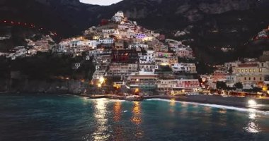 Positano 'nun havadan görünüşü. Gece vakti ışık saçan ünlü renkli evler. İtalya, Amalfi Sahili 'nde muhteşem bir mimari..