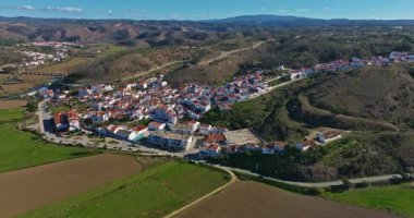 Yel değirmeni ve pitoresk çatıları olan küçük köyün havadan görünüşü, Aldatmaca, Portekiz.