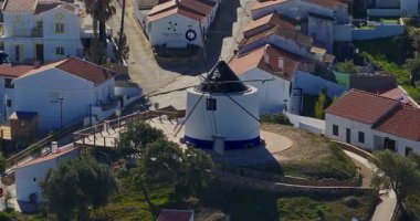 Yel değirmeni ve pitoresk çatıları olan küçük köyün havadan görünüşü, Aldatmaca, Portekiz.