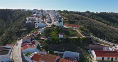 Yel değirmeni ve pitoresk çatıları olan küçük köyün havadan görünüşü, Aldatmaca, Portekiz.