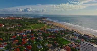 Arka planda ünlü bir köprü olan Portekiz 'deki bir kalenin insansız hava aracı görüntüsü. Portekiz, Carcavelos sahilinden deniz feneri kulesi olan Aziz Julian Kalesi. Carcavelos 'taki Atlantik okyanus dalgaları plajı.