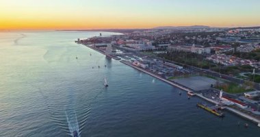 Portekiz, Lizbon 'da gün batımında Tagus Nehri üzerindeki 25 de Abril köprüsünün hava görüntüsü.