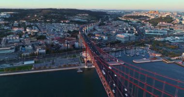 Portekiz, Lizbon 'da gün batımında Tagus Nehri üzerindeki 25 de Abril köprüsünün hava görüntüsü.