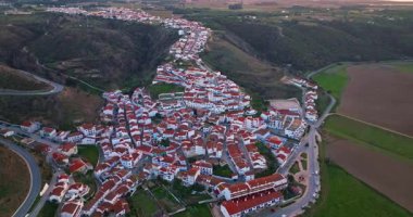 Yel değirmeni ve pitoresk çatıları olan küçük köyün havadan görünüşü, Aldatmaca, Portekiz.