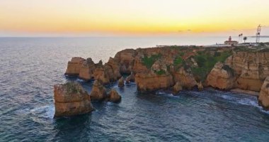 Günbatımında Ponta da Piedade, Lagos, Portekiz 'deki dramatik uçurumların ve deniz fenerinin havadan görünüşü.