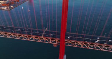 Portekiz, Lizbon 'da gün batımında Tagus Nehri üzerindeki 25 de Abril köprüsünün hava görüntüsü.