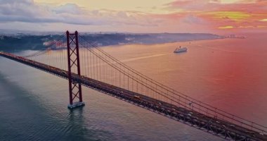  Portekiz, Lizbon 'da gün batımında Tagus Nehri üzerindeki 25 de Abril köprüsünün hava görüntüsü.