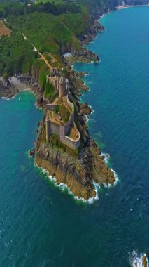 La Latte Kalesi 'nin havadan görünüşü, Cap Frehel, Brittany, Fransa' daki Chateau de la Roche Guyon kumtaşı kayalıklarında dalgaların ezdiği güneşli bir yaz gününde.