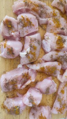 Mutfak tahtasındaki baharatlı çiğ tavuk parçaları, taze yiyecek. 