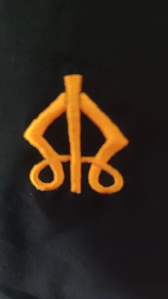 stock image embroidery symbol orange thread on black fabric. High quality photo