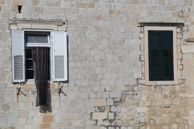 Hırvatistan 'ın Dubrovnik kentinde 22 Nisan 2023' te inşa edilen beyaz ahşap panjurlu taş duvar ve pencere. Yüksek kalite fotoğraf