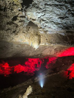 Prometheus Mağarası, Gürcistan, Kumistavi mağarası, doğa parkı eşsiz rezervi, turistler, kırmızı ışık dünya sarkıtları dikitler karanlık, kapalı uzay turizm merkezi nesneleri Tskaltubo yakınlarında seyahat ediyor.