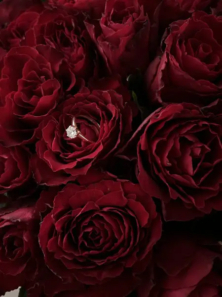 Bir buket gülün içinde nişan yüzüğü.