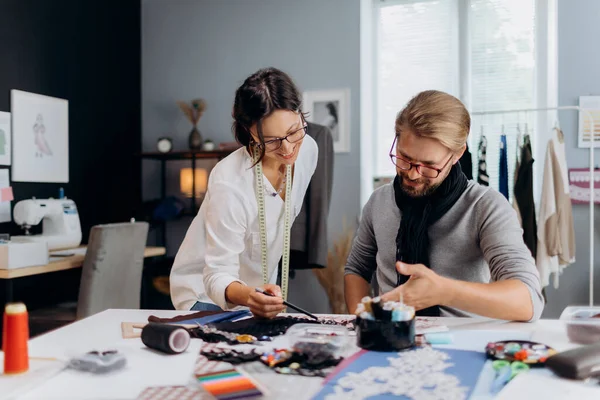 stock image Talented caucasian couple in stylish wear designing clothes collection at own modern atelier. Mature man and woman sharing ideas and having discuss during working process.