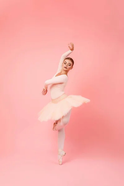 迷人的年轻女子 身体灵活 在粉色工作室背景下表演芭蕾舞动作 穿着拖鞋和尖鞋的职业芭蕾舞演员 — 图库照片