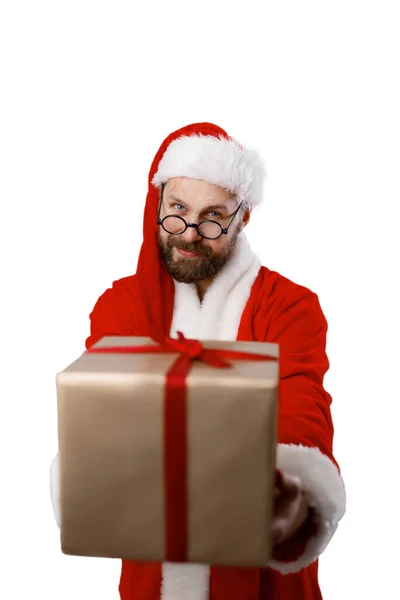 留着胡子的成熟男子 头戴红色的桑塔帽 身穿灰色工作室背景包装礼品盒的衣服 寒假和礼物的概念 — 图库照片