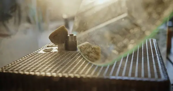 stock image Artistic close-up of a glass edge being ground on a specialized machine in a sunlit artisan workshop, emphasizing the precision and beauty of the glass crafting process.