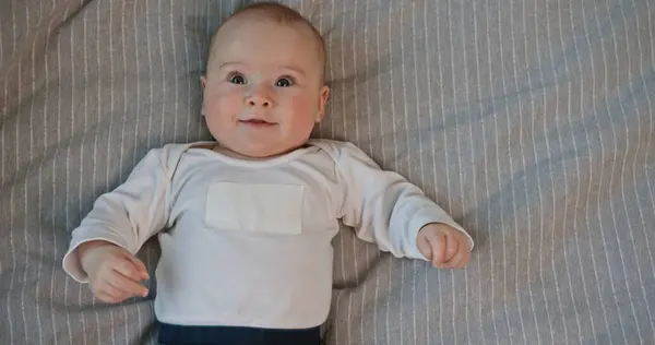 stock image Cheerful Baby Boy Laughing Lying on a Bed Looking at Camera. High quality 4k footage